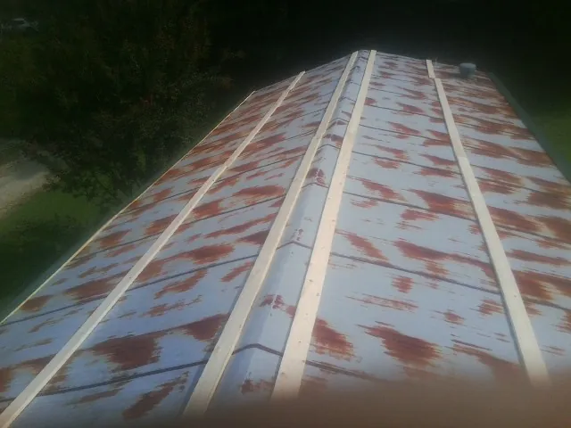 Rusted metal roof panels with new wood purlins before replacement — Storm Damage Roof Repair in Powers by Roofing Brothers