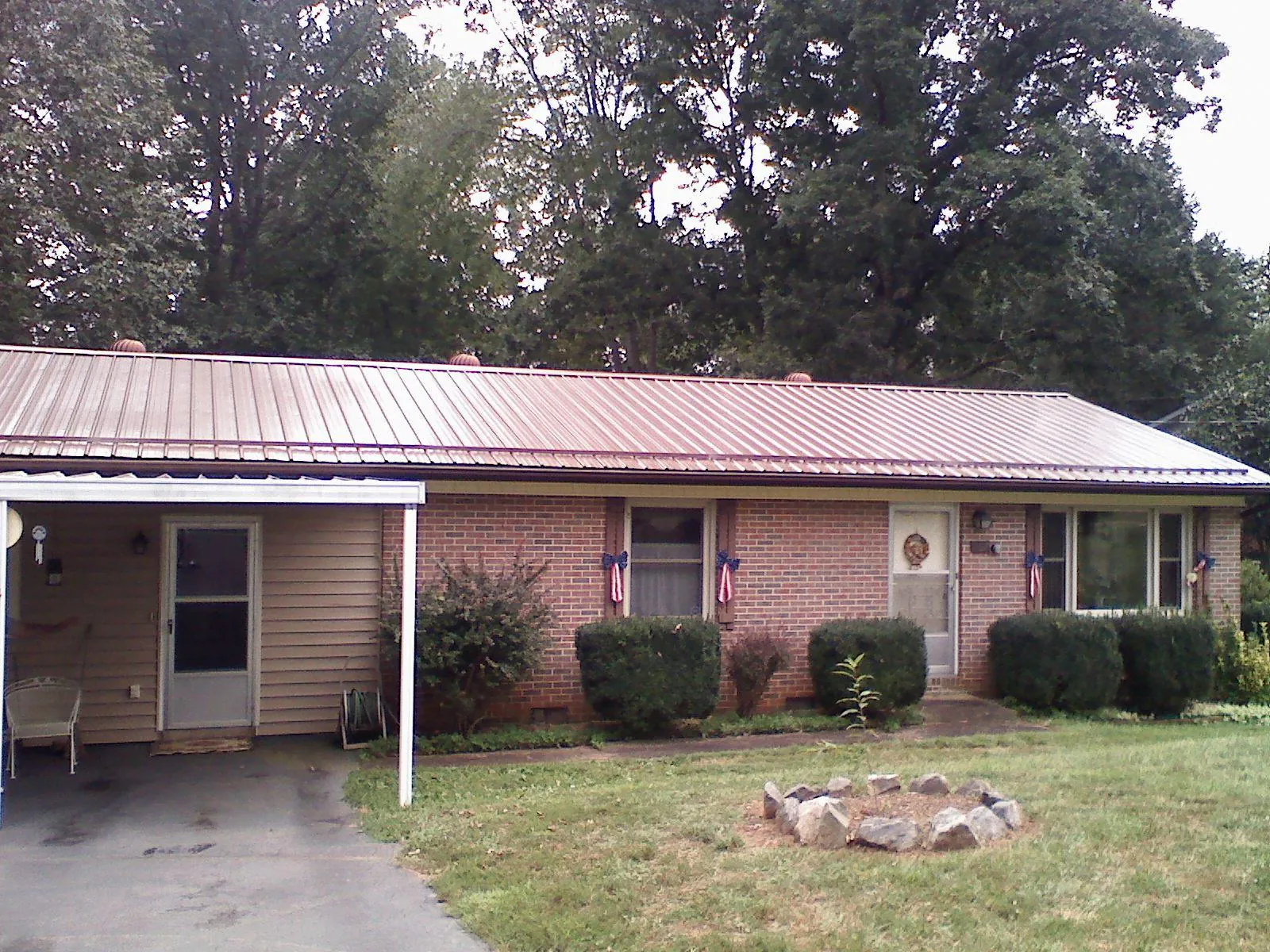 Bronze metal roof and carport on a brick ranch home — Roof Repair work by our crew in Powers